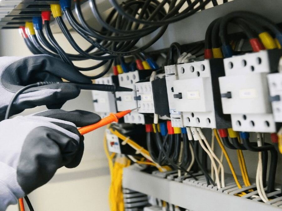 Technician testing an electrical distribution panel